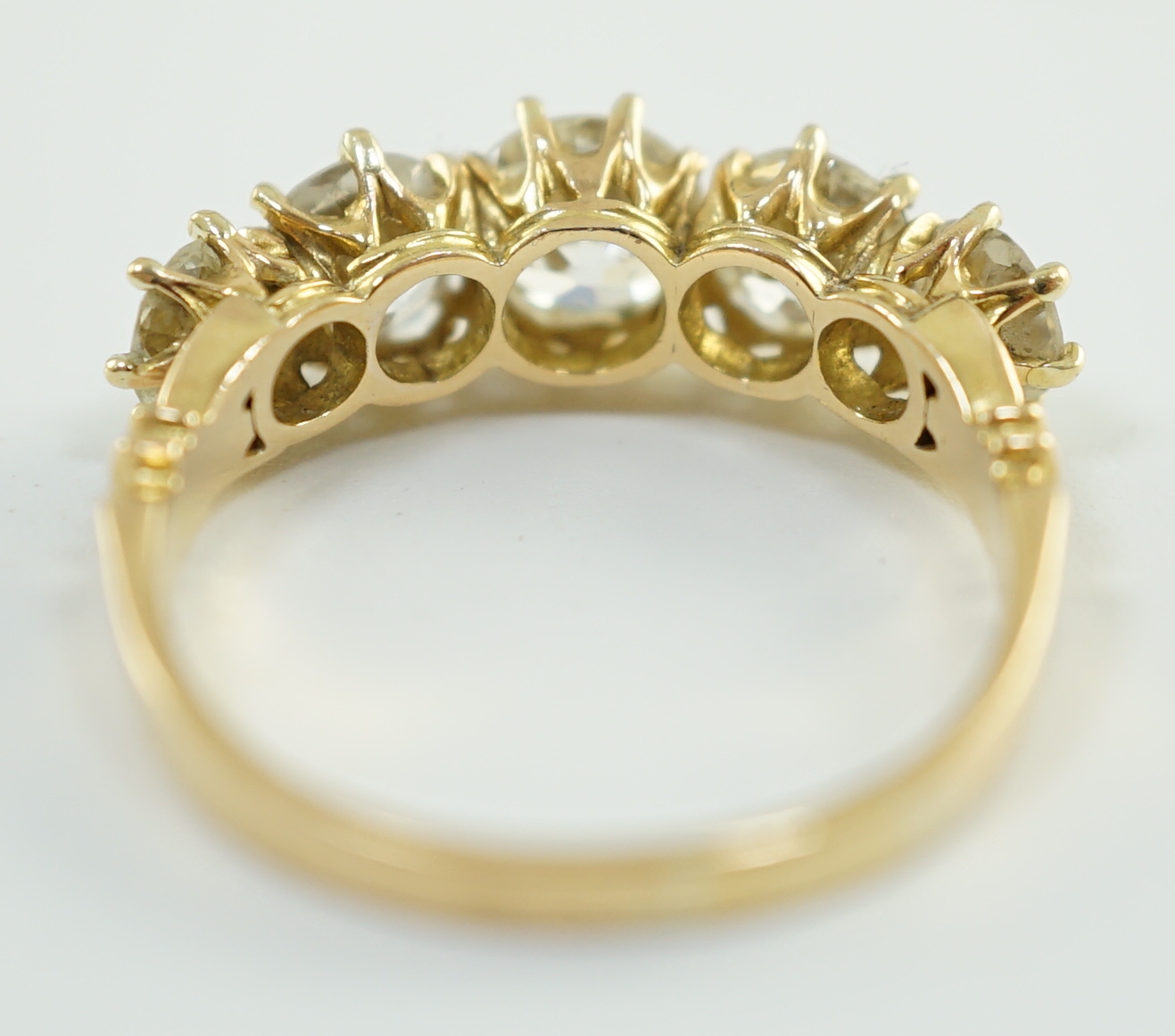 An 18ct gold and graduated five stone diamond set half hoop ring